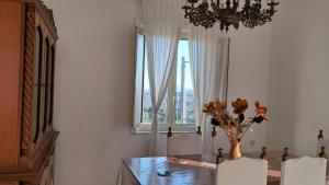 a dining room with a table and a vase with flowers at Affitti Brevi da Rita in Monte di Procida