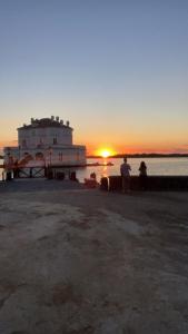 two people sitting on a bench watching the sunset at Affitti Brevi da Rita in Monte di Procida
