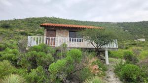 a small house on a hill with a bench at Cabaña Refugio del Silencio Ixmiquilpan in Ixmiquilpan