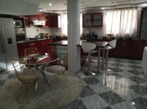 a kitchen with a table and chairs and a counter at Villa Harmonie - Suite Familiale avec Piscine in Khemisset