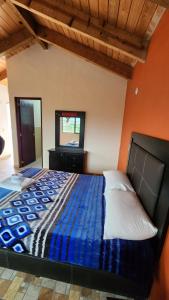 a bedroom with a bed with a blue comforter and a mirror at Cabaña Refugio del Silencio Ixmiquilpan in Ixmiquilpan +14 photos