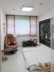 a bedroom with a large bed and a chair at 핑크하우스옥상바베큐파티 in Daejeon +20 photos