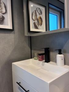 a bathroom with a white sink and a mirror at Luxe Boshuisje Lodge Wildblick, adults only Haarle, Sallandse Heuvelrug in Haarle +38 photos