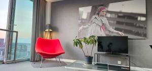 a living room with a tv and a red chair at Namah peace in Birmingham