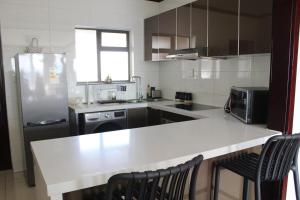 a kitchen with a white counter top and a refrigerator at First Gen Cedar Acres Fourways in Trevallyn