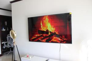 a fireplace with a tv on a white wall at First Gen Cedar Acres Fourways in Trevallyn