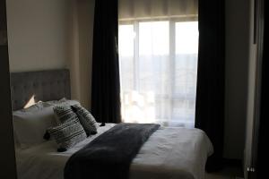 a bedroom with a bed with a large window at First Gen Cedar Acres Fourways in Trevallyn