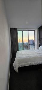 a bedroom with a bed with a view of a city at Shivay Harmony in Birmingham