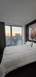 a bedroom with a large bed with a large window at Shivay harmony in Birmingham