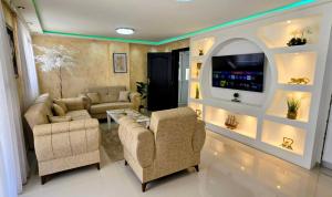 a living room with two couches and a tv at Villa Imperial in Dobra Voda