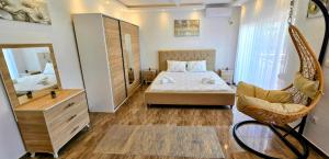 a bedroom with a bed and a mirror and a chair at Villa Imperial in Dobra Voda