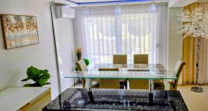 a dining room with a glass table and chairs at Villa Imperial in Dobra Voda