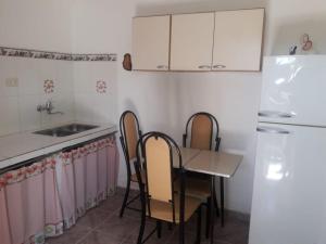 a kitchen with a table and chairs and a refrigerator at Departamento Los Rosales in Villa Cura Brochero