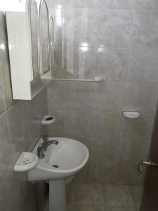 a white bathroom with a sink and a shower at Departamento Los Rosales in Villa Cura Brochero