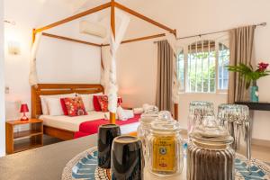 a room with a bed and a table with glasses at Casa Mapache Pool and Breakfast Included near Tamarindo Beach in Tamarindo