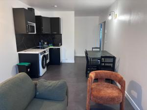a living room with a couch and a table and a kitchen at Michèle Home in Orly