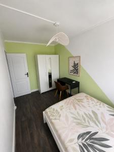 a bedroom with a bed and a desk in it at Michèle Home in Orly