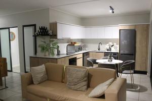a living room with a couch and a kitchen at First Gen lagoon facing luxury apartment in Pretoria