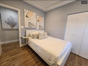 a bedroom with a bed and a painting on the wall at Endless Summer Cottage - Steps off Atlantic! in Delray Beach