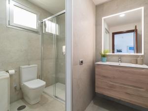 a bathroom with a toilet and a sink and a mirror at HolaMogamar in Puerto de Mogán +26 photos