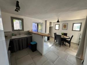 a kitchen and dining room with a counter and a table at Maison Icard in Sault-de-Vaucluse