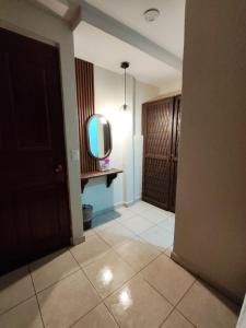 ein Flur mit einem Fernseher, der auf einem Tisch in einem Zimmer steht in der Unterkunft Hotel Tradicional Savaro SA de CV in Zihuatanejo
