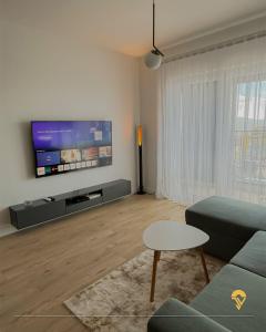 a living room with a couch and a flat screen tv at Tian Vista Apartment in Prishtinë