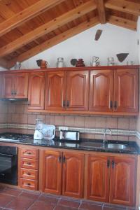 a kitchen with wooden cabinets and a sink at Casa La Bodega in Hermigua