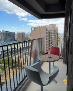 a balcony with a table and chairs and a view of a city at Tian Vista Apartment in Prishtinë
