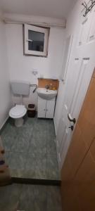 a bathroom with a toilet and a sink and a door at Daria in Eforie Sud