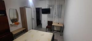 a bedroom with a bed and a table and a desk at Daria in Eforie Sud