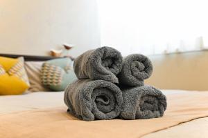 a pile of towels stacked on top of a bed at Grace Hotel Kyodo odakyu line near shinjuku shibuya in Tokyo +39 photos