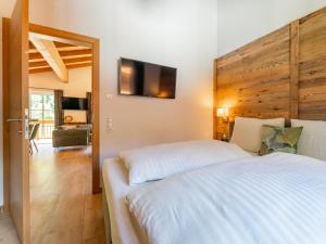 a bedroom with a bed and a television on the wall at Felsener Wald in Wald im Pinzgau