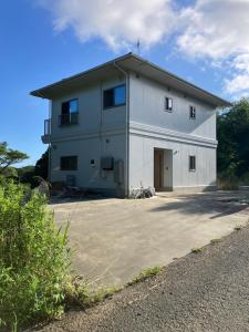 a large white building with a garage at Ocean view Private Hotel in Shimoda
