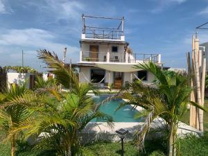 a house with a swimming pool and palm trees at Secret Garden Cottage in El Naranjo