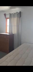 a bedroom with a bed and a dresser and a window at Casa La Tirana Parcela 43 in La Tirana