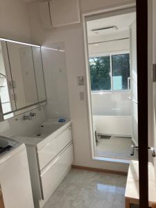 a white bathroom with a sink and a mirror at Ocean view Private Hotel in Shimoda +26 photos