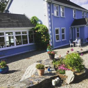 ein blaues Haus mit Topfpflanzen davor in der Unterkunft Five Oaks Bed & Breakfast with free parking, tranquil setting in Derry Londonderry