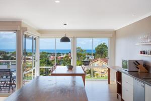 a kitchen with a table with a view of the ocean at Wild Views in Tathra