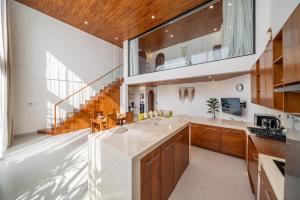 a kitchen with wooden cabinets and a large window at Darina Villa - Private Rooftop Escape with Pool Close to Beach in Badung