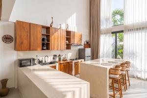 a kitchen with wooden cabinets and a white counter top at Darina Villa - Private Rooftop Escape with Pool Close to Beach in Badung