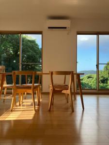 a dining room with a table and chairs and windows at Ocean view Private Hotel in Shimoda