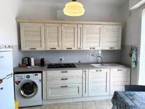 a kitchen with white cabinets and a washing machine at Casa Vacanza Latte in Latte