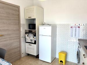 a kitchen with a white refrigerator and a microwave at Casa Vacanza Latte in Latte