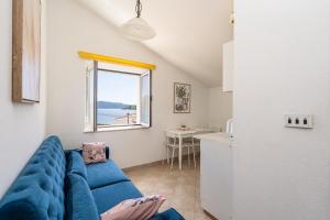 a living room with a blue couch and a kitchen at Apartments and rooms by the sea Slano, Dubrovnik - 2687 in Slano