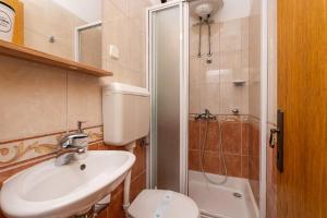 a bathroom with a sink and a toilet and a shower at Apartments and rooms by the sea Slano, Dubrovnik - 2687 in Slano