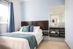 a bedroom with a large bed and a mirror at Hotel Mar y Arte in Piriápolis