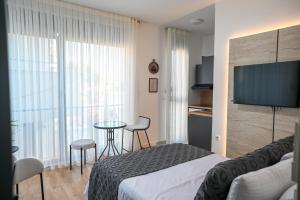 a hotel room with a bed and a table and a television at Hana boutique apartments in Ulcinj