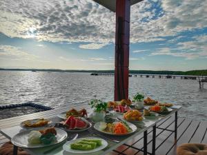 a table with plates of food on the water at Sea Balcony Cottage in Satun