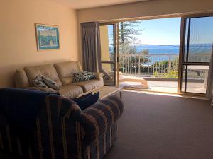 a living room with a couch and a view of the ocean at Sea Eagles Unit 4 in Caloundra